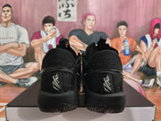 Rear view of a pair of black basketball shoes with embroidered heel details.