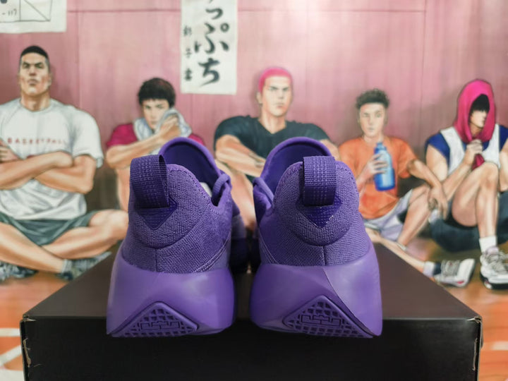 Rear view of a pair of purple Nike low-top sneakers showing the heel panels and pull tabs.