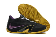 Black basketball shoe shown beside its gold-colored outsole with a geometric tread pattern.