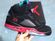 Side view showing black upper panels, red 23 embroidery, purple and turquoise details, and a translucent outsole.
