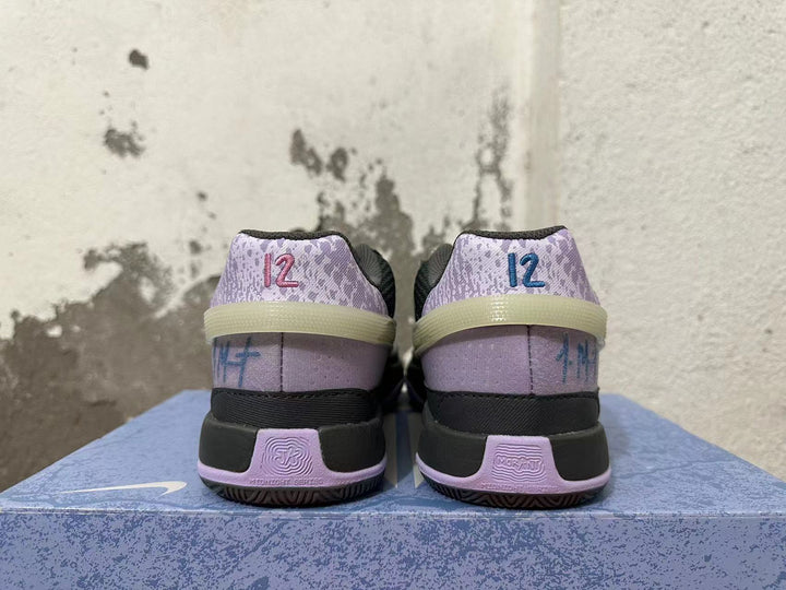 Rear view of black and lavender Nike basketball shoes with patterned heel panels