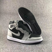 High-top sneaker displayed with one shoe lifted to reveal the black patterned outsole.