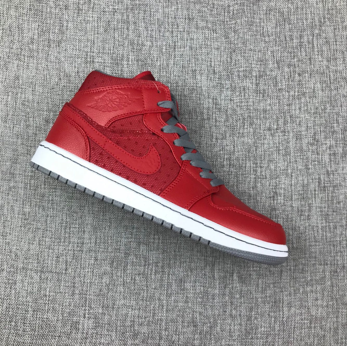 Single red high-top sneaker shown from the lateral side with gray laces, white midsole, and gray outsole.