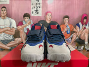 Front view of the pair showing the white toe areas, blue overlays, red accents, laces, and front straps.