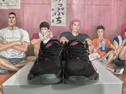 Front view of the black basketball sneakers showing black laces, pink tongue logos, and translucent outsoles.