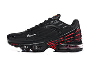 Side view of a black Nike Air Max Plus III sneaker with red accents and visible sole cushioning.