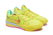 Three-quarter view of the pair of yellow shoes with mint-green accents and contrasting side graphics.
