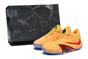 Yellow and orange basketball shoes pictured beside a dark shoe box