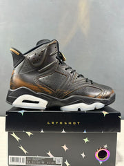 Close side view of the black perforated upper and bronze-toned detailing; the box label identifies IR7572-220 and a photographed EU 42 sample.