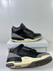 Angled view highlighting the black upper, gray overlays, cream midsole, and outsole tread.