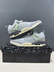 Two Jordan Spizike Low sneakers displayed in profile with elephant-print toe and heel detailing, pale green accents, and dark grey midsoles.