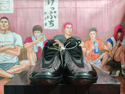 Front view of a pair of black lace-up sneakers with sculpted side panels