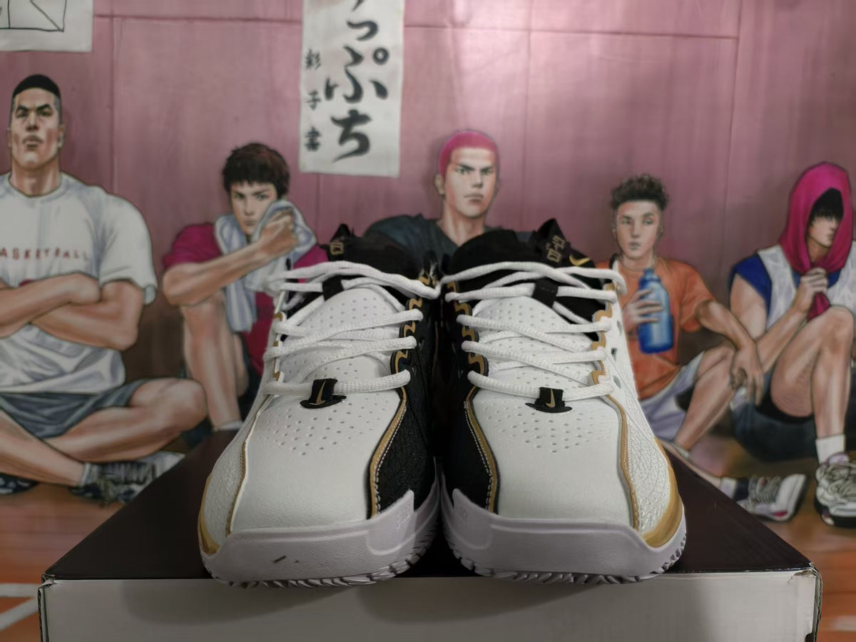 Pair of white, black, and gold Nike basketball sneakers shown from the front on a shoe box.