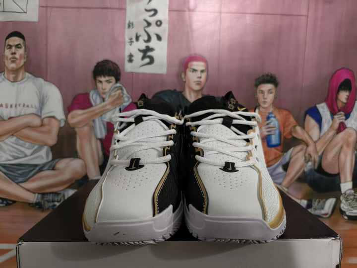 Pair of white, black, and gold Nike basketball sneakers shown from the front on a shoe box.
