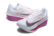 White Nike Zoom Fly 6 shoes with black Swoosh graphics and purple, pink, and coral sole accents.