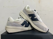 New Balance U370 sneakers displayed together, showing the side logo and layered upper.