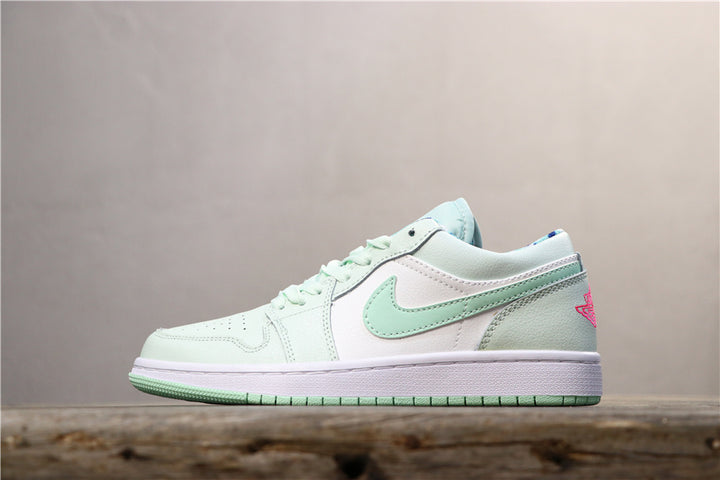 Side view of pale green, white, and pink low-top sneakers with a side swoosh and Jordan wing-style heel logo.