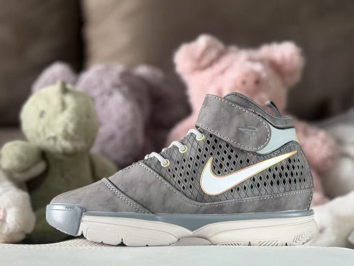 Side view of a gray high-top kids' sneaker with a patterned side panel, light swoosh-style detail and white outsole.