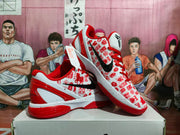 Pair of red and white basketball sneakers displayed on a box, showing the patterned upper, black Swoosh, and red outsole.