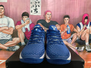 Front view of blue Nike basketball sneakers with textured uppers, dark laces, white tongue branding and white midsoles.