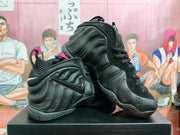 Black Foamposite-style high-top sneakers shown from the side, with molded panels and a lace-up front