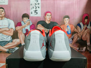 Rear view of the pair showing gray uppers, white heel panels, orange collars, and Jumpman branding.