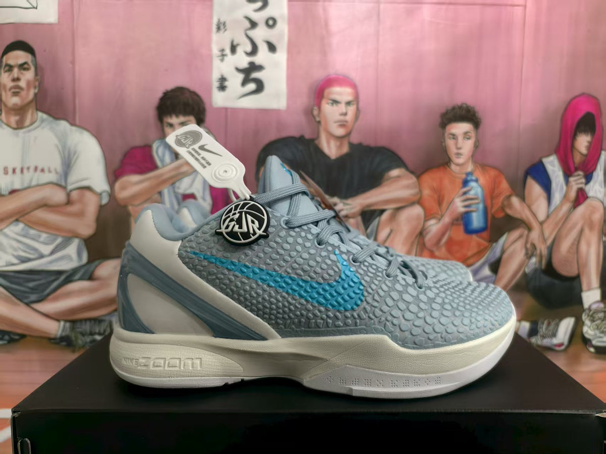 Side view of grey and blue Nike Caitlin PE basketball sneakers showing the textured upper, blue Swoosh and layered sole.