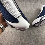 Close-up of the white toe, laces, and navy side panel on an Air Jordan 13 Flint.