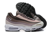 Nike sneakers shown from the side and underside, with a black tread outsole and visible Air units.