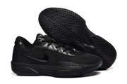 Side and outsole view of the black sneakers, showing the tonal side mark and densely patterned rubber tread.