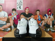 Front view of white and black Jordan sneakers with white laces and glossy black toe overlays