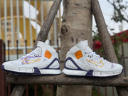 Side-by-side profile view of the white, purple, gold, and orange high-top shoes