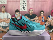 Side view of a teal basketball sneaker featuring a red Nike swoosh, black claw-like detailing, and a white midsole.