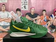 Side view of a green Nike basketball sneaker showing the yellow Swoosh, laces, patterned side panel, and white midsole section.