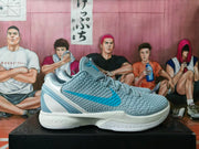 Side view showing the gray textured upper, blue Nike swoosh, padded collar, and translucent blue heel structure.