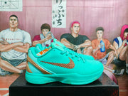 Side profile of a turquoise basketball sneaker featuring a bronze swoosh, bronze heel accent, and sculpted sole.