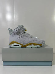 Side profile of a white Jordan Air Jordan 6 high-top sneaker with gold midsole accents.