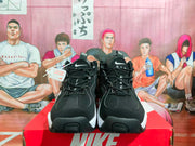 Front view of black Nike sneakers showing the Swoosh, AIR lettering, laces and white midsole accents.