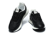 Pair of black lace-up sneakers shown from the front and at an angle.