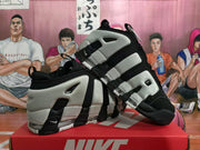Angled view of the pair of black and grey Nike sneakers displayed on a Nike shoe box.
