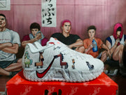Side view of white Nike basketball sneakers with a red Swoosh, colorful animal-themed graphics, textured panels, and Zoom branding.