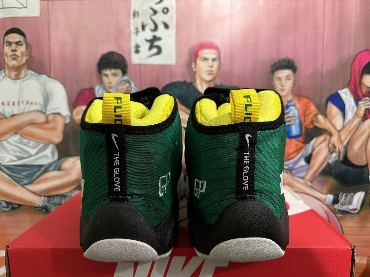 Front view of dark green high-top basketball sneakers with black trim, yellow lining and white toe sections.