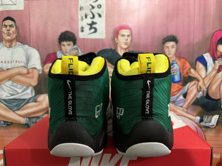 Front view of dark green high-top basketball sneakers with black trim, yellow lining and white toe sections.