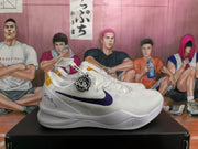 Side view of a white basketball sneaker showing a purple Nike Swoosh, gold heel accent, and white midsole.