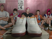 Front view of white low-top basketball sneakers with blue and gum-toned outsole accents.