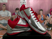 Angled view highlighting the silver side panels, red Swoosh branding and red outsole.