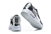 Rear and outsole views of silver Nike Air Max 90 sneakers.