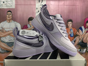 Angled view of the pair of purple Nike sneakers displayed together, showing the side Swooshes and layered upper panels.