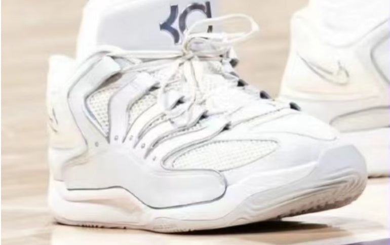 Silver-toned low-top sneakers with layered panel details, dark accents, and a textured outsole shown from a front-side angle.
