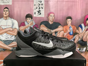 Side profile of a black and gray basketball sneaker showing the white side branding, textured upper, angular midsole, and white outsole accents.
